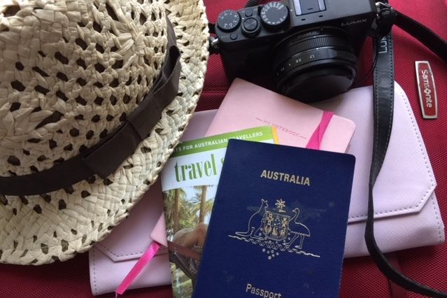 Passports, notebook, hat and camera - travel essentials.